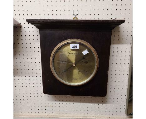 An early 20th Century stained oak framed Aitchison (London &amp; Provinces) wall barometer with brass dial and aneroid works