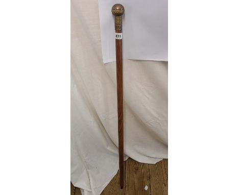 A modern walking cane with brass handle containing enclosed compass