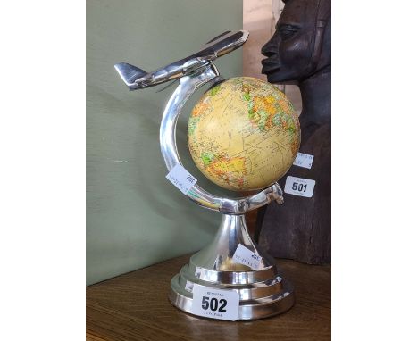 A modern globe on stand decorated with an aeroplane finial
