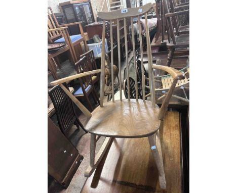 A Ercol light elm and mixed wood stick back rocking chair with sectional moulded elm seat, bearing blue label