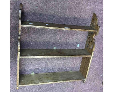 A 59cm early 20th Century oak wall hanging three shelf waterfall open bookcase with pierced decoration
