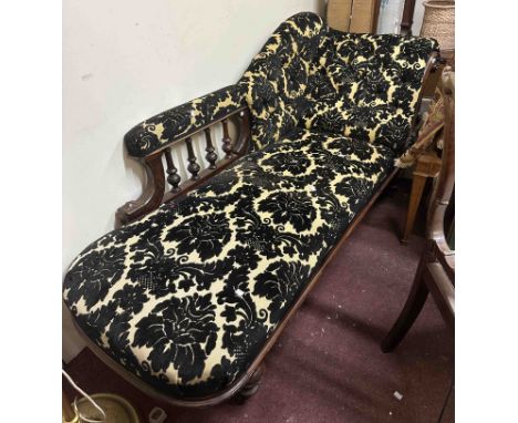 A 1.8m late Victorian chaise longue with button floral Damask upholstery and carved detail to the part show frame, set on tur