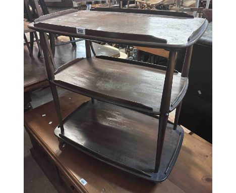 A vintage Ercol dark elm three tier tea trolley, set on Shepherd casters