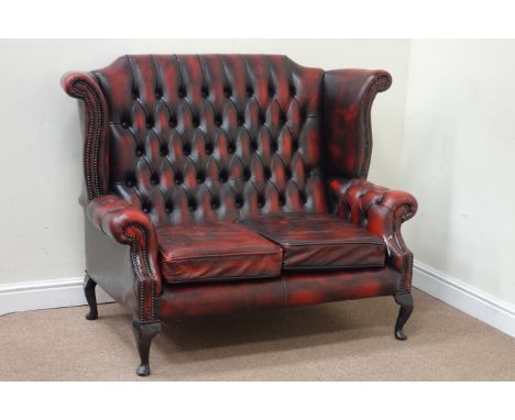 Wingback two seat sofa upholstered in buttoned red leather, W142cm Condition Report Click here for further images, condition,