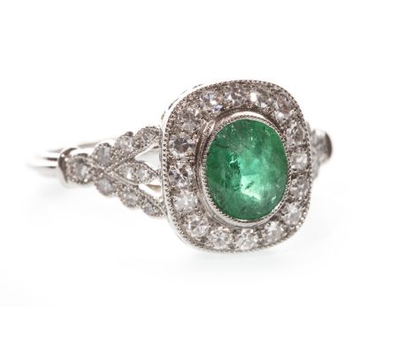 EMERALD AND DIAMOND RING, Edwardian style, the bezel 11.5mm long and set with a central oval emerald, within a diamond halo, 