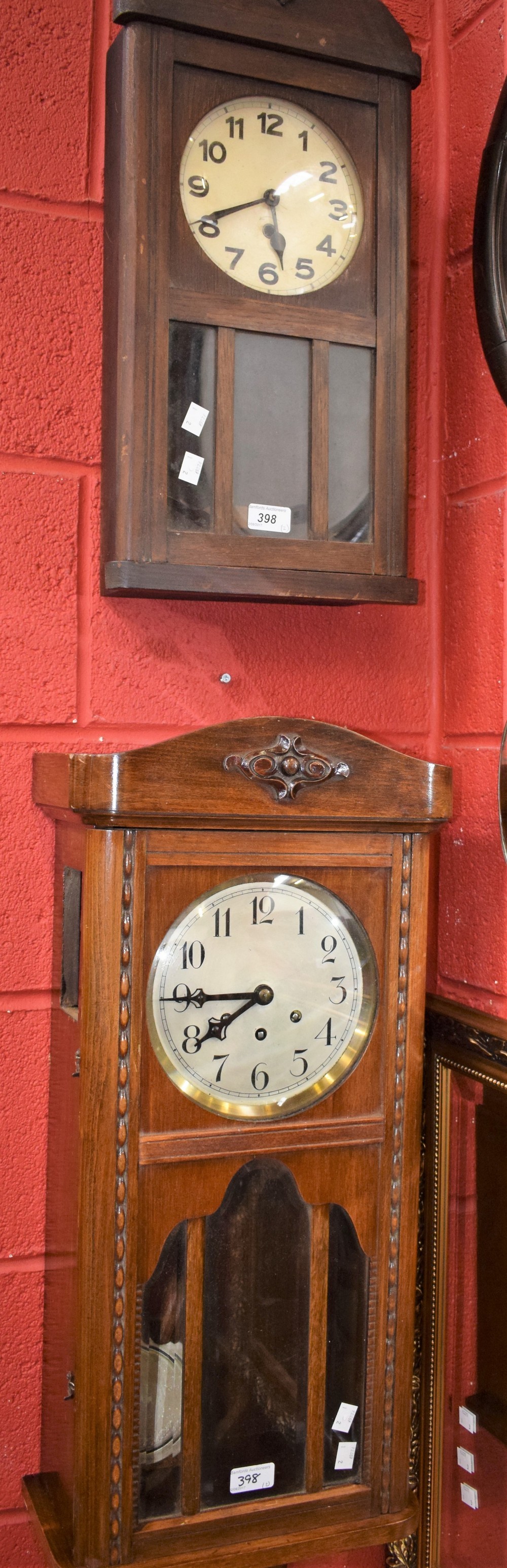 An early 20th century wall clock, three winding holes, pendulum and key
