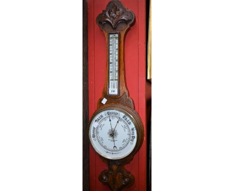 A carved oak Victorian aneroid barometer