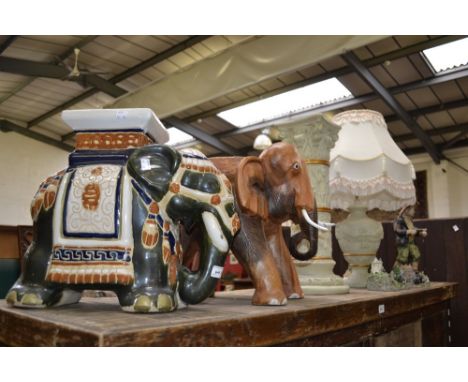 A carved wooden stool modelled as an elephant; another, ceramic jardiniere stand; an Empire style urnular lamp and Corinthian