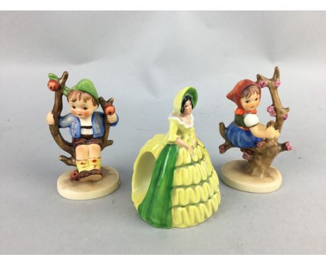 CARLTON WARE NAPKIN RING, in the form of a lady, 9.5cm high, along with a pair of Goebel apple tree boy and girl figures