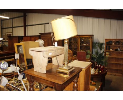 A stripped pine stool and a brass lamp and shade 
