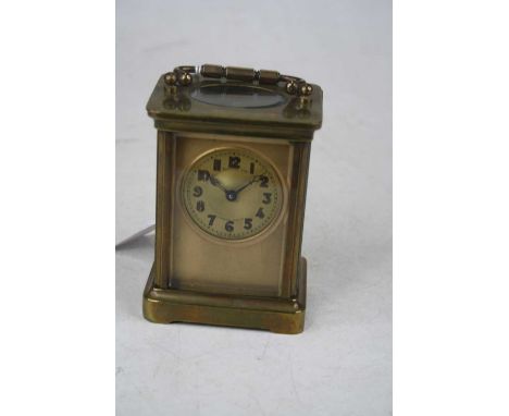 An early 20th century lacquered brass cased carriage clock, the circular dial with Arabic numerals signed Harrods Ltd, London
