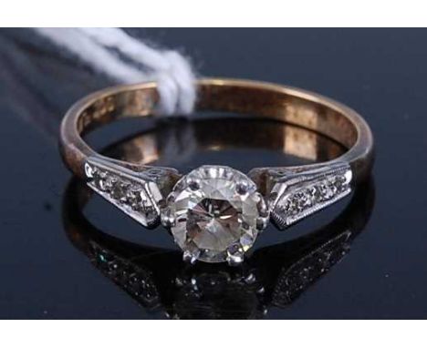 A yellow and white metal diamond single stone ring, comprising a round brilliant cut diamond in a six-claw setting, with thre