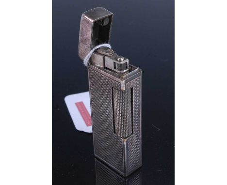 A Dunhill engine turned steel pocket cigarette lighter, 6.5cmCondition report: Some signs of tarnishing, most notably to lid.