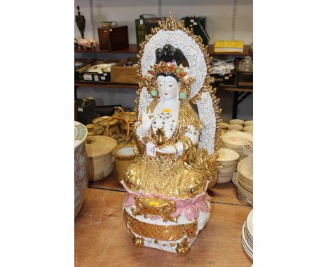 A large modern ceramic model of a Hindu goddess, in typical seated lotus pose with gilt decoration, h.69cm