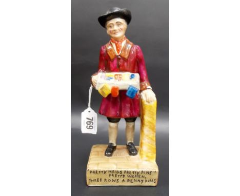 Rare Clarice Cliff Wilkinson Ltd pottery figure modelled as a pin seller, he is holding a basket, to the base is inscribed 'P