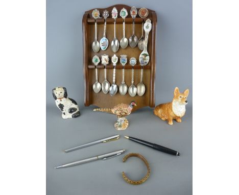 Quantity of collector's spoons on a wooden rack, a Sylvac corgi and a Staffs comforter dog, a gilt and enamel jewel decorated
