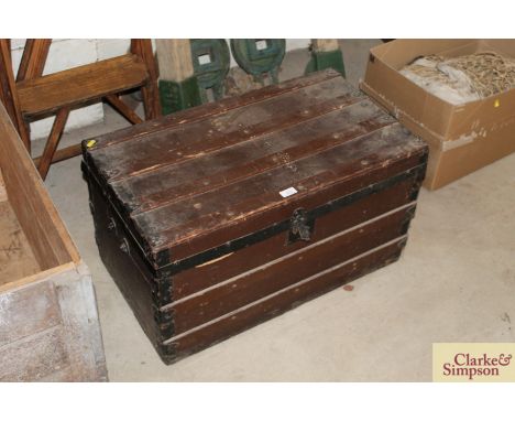 A vintage wooden trunk with metal mounts and carrying handles 