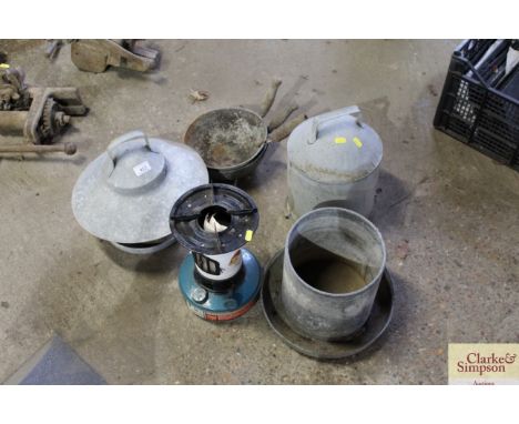 Two galvanised chicken drinkers, three vintage feed scoops and a paraffin heater
