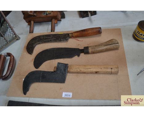 Three vintage hand hooks mounted on a board