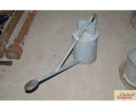 A vintage galvanised watering can with long spout and copper rose 