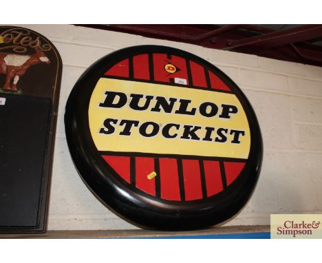 A circular metal "Dunlop Stockist" advertising sign, approx. 24" dia.