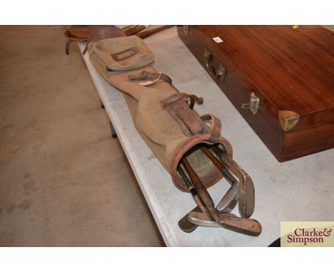 A canvas and leather vintage golf bag containing four old hickory shafted clubs including a Bunny putter, Scottish made Range