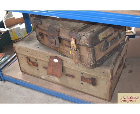 A canvas and leather wheeled trunk and a strapped and labelled suitcase