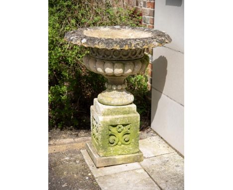 A PAIR OF EARLY VICTORIAN CARVED COTSWOLD STONE VASES ON PLINTHS  CIRCA 1840  each 107cm high overall, the vases 8cm diameter