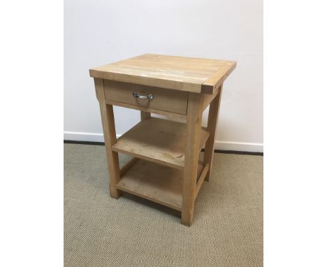 A modern beech veneered butcher's block type table with single drawer above two shelves on chamfered supports, 65 cm wide x 6