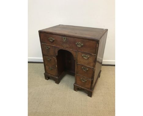 A 19th Century walnut kneehole desk in the early 18th Century manner, the quartered feather-banded top with moulded edge over