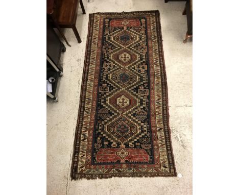 A fine Shirvan runner, the central panel set with repeating medallions on a dark blue stylised flower head decorated panel wi