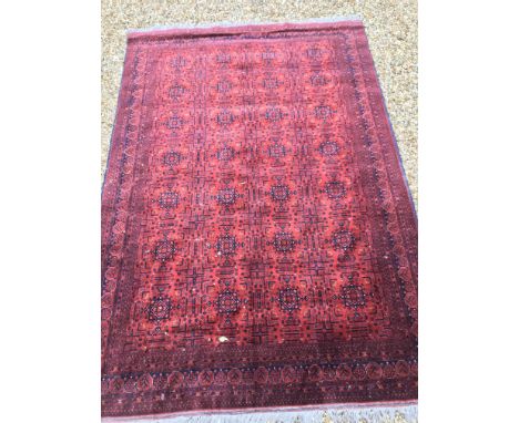 A Bokhara type carpet, the central panel set with repeating medallions on a dark red and black geometric patterned border, ap