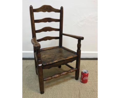 A 19th Century child's ash and elm panel seat ladder back elbow chair on turned legs united by stretchers, 41 cm wide x 32 cm