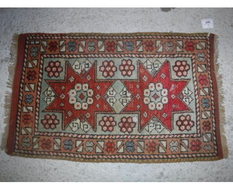 A Caucasian rug, the central panel set with two star shaped medallions on a mint green ground, within a stepped orange and cr