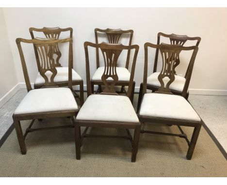 A set of six modern Provincial Chippendale style vase back dining chairs with upholstered seats on square supports united by 