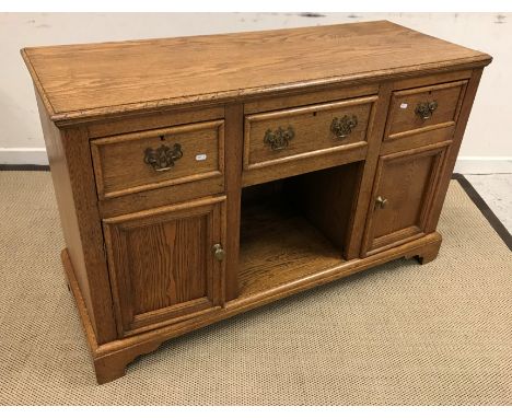 An oak dresser in the Victorian manner, the top with moulded edge above three drawers and dog kennel flanked by two cupboard 