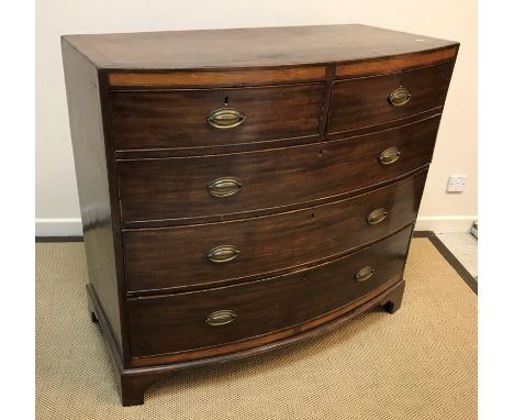 A Regency mahogany bow fronted chest, the cross-banded top over a satinwood banded frieze and two short over three long gradu
