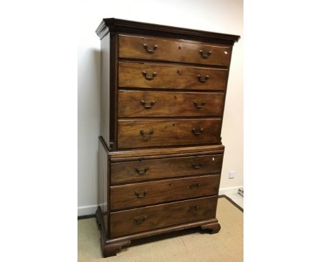 A 19th Century mahogany bachelor chest on chest, the moulded dentil cornice over four long graduated drawers with brass swan 