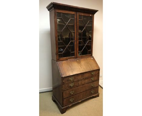 A George III mahogany bureau bookcase, the upper section with astragal glazed doors enclosing shelves over a sloping fall enc