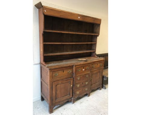 A late George III elm breakfront dresser, the three tier boarded plate rack over a single central drawer and three dummy draw