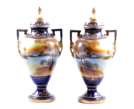 A pair of Noritake twin-handled lidded vases, lake scene to bodies, 42.5cm.Qty: 2Condition report:Both vases have loss of gil