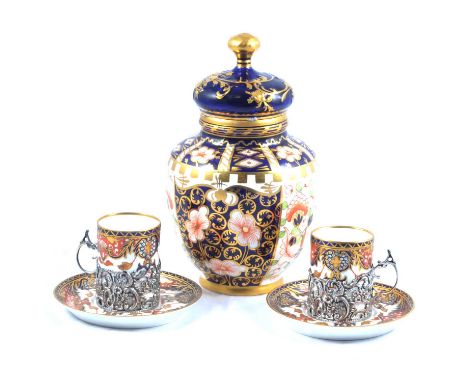 A set of six Royal Crown Derby demi-tasse in silver decorative floral pierced holders, London import mark on silver for 1909,