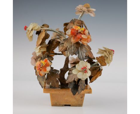 A vintage floral arrangement featuring intricately carved soapstone flowers in hues of cream, peach, and pink, with detailed 
