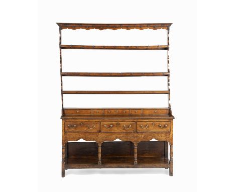 A WELSH 18TH CENTURY OAK DRESSERThe plate rack with iron hooks above five spice drawers, the base fitted with three drawers a