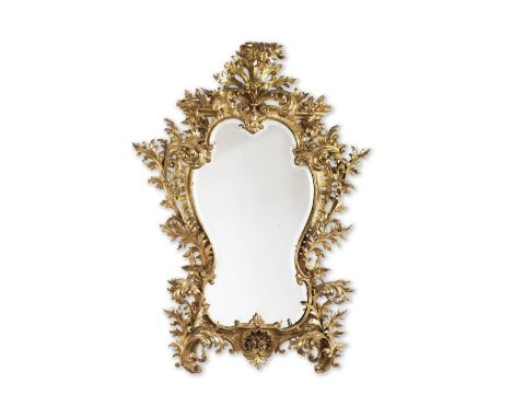 AN ITALIAN CARVED GILTWOOD MIRRORMid-19th centuryThe finely bevelled cartouche plate within an elaborate acanthus leaf pierce