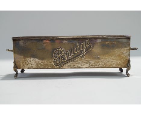 A silver bridge card holder, Chester, date letter rubbed, circa 1912, of trough form with lion mask drop ring handles and on 
