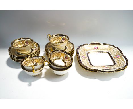 A Cauldron tea service, richly decorated with gilding and flowers over a blue ground, seven place setting, comprising cups an
