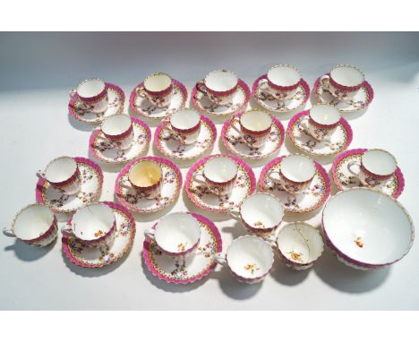 A 19th century part tea service, printed and painted with flowers and a pink border, comprising nine large cups, eleven small