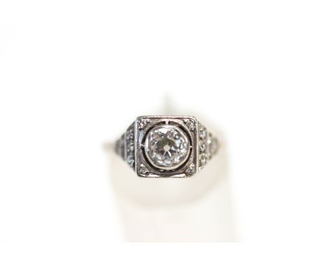A diamond ring, circa 1925, stamped 'Plat', the old brilliant cut of approximately 0.6 carats, between stepped shoulders set 