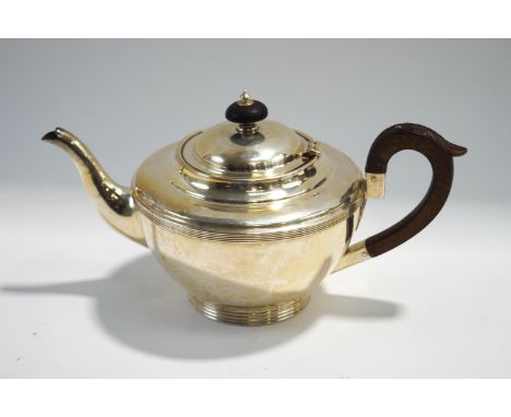 A silver teapot, by H.Wilkinson, Sheffield 1926, of hemispherical form with reeded border on a reeded rim foot, 24 cm long, 4